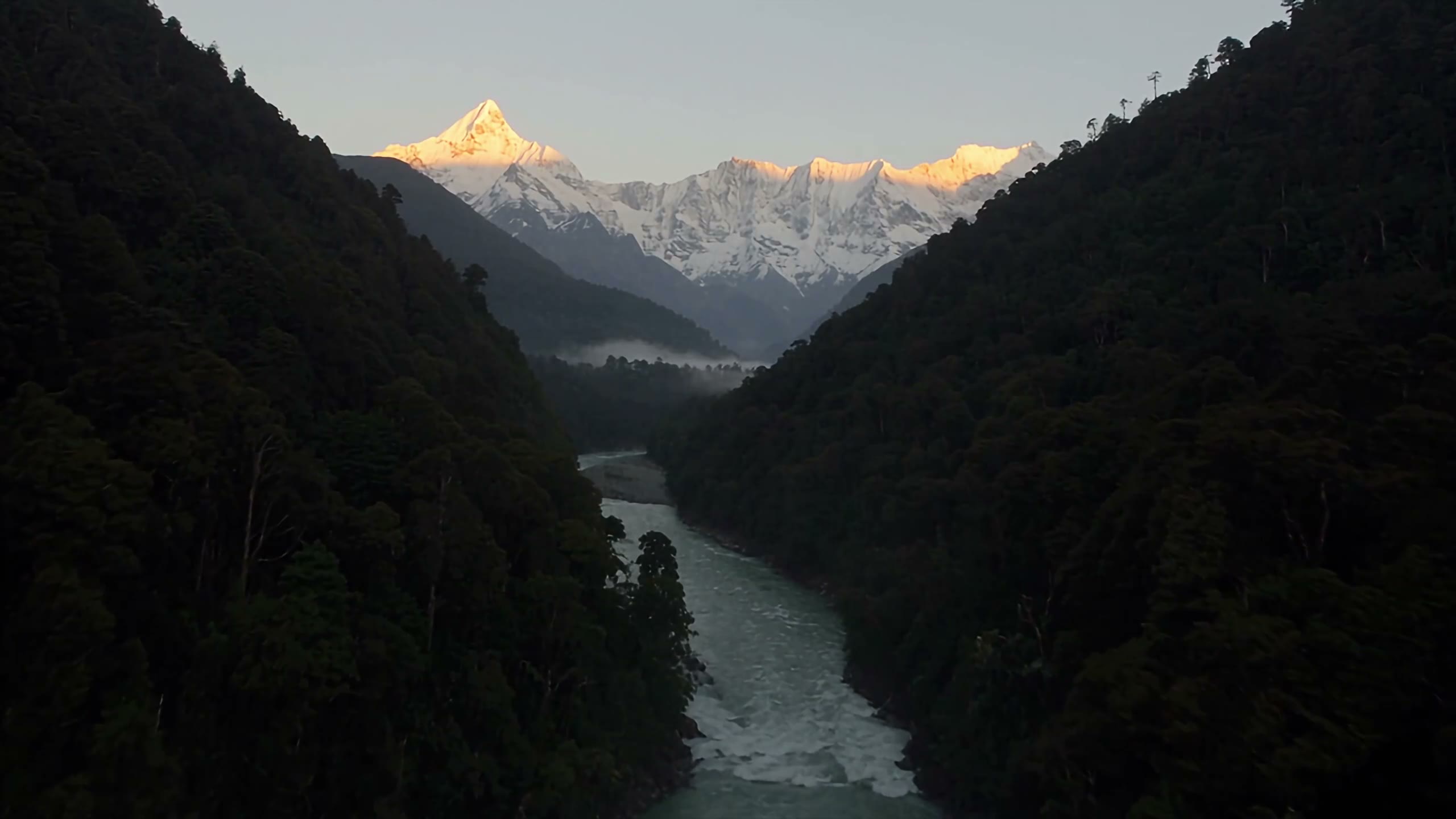 A river running through a green mountain valley in Nepal